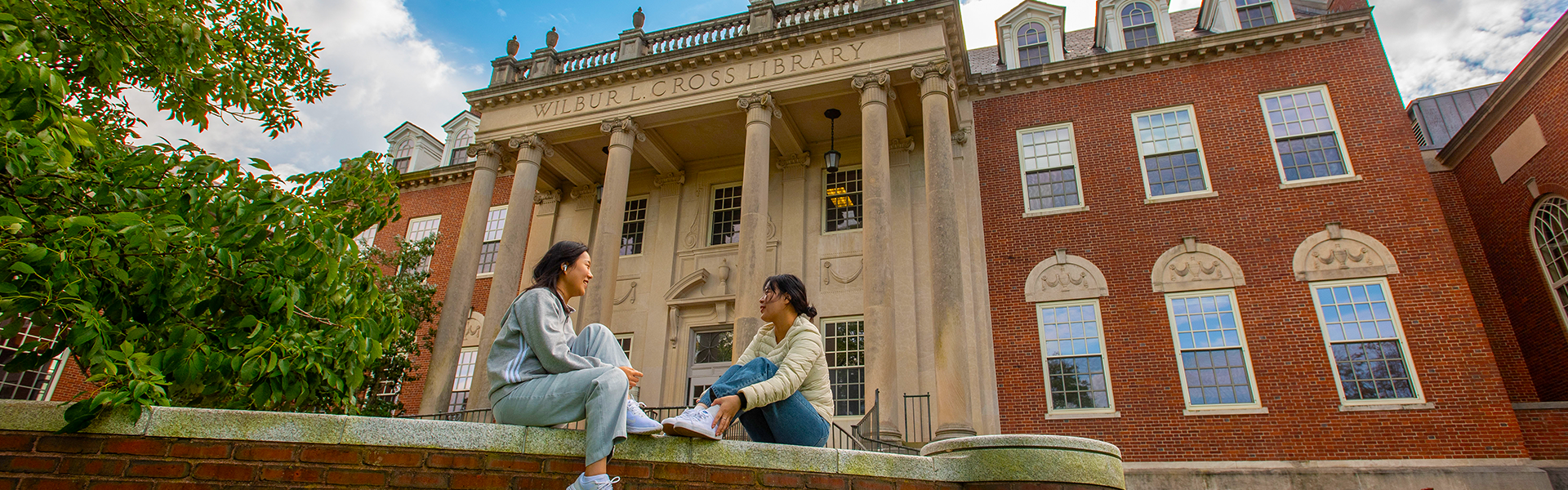 Students sitting outside Wilbur Cross Building, Storrs